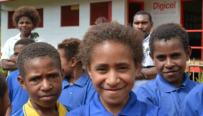 A group of Papua New Guinean children in front of a Digicel Foundation classroom