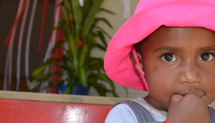 A young child wearing a pink hat