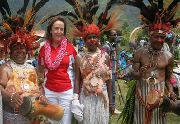A Digicel staff member smiling with Papua New Guinean people in traditional dress